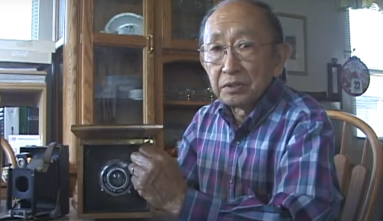 archie miyatake with his father's homemade camera that he snuck into camp